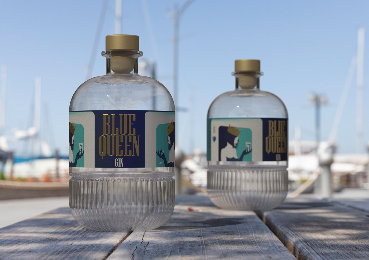 Ambiente esterno: In Primo piano due bottiglie (una più vicina dell'altra) di Blue Queen Gin Appoggiate su un tavolo in legno. Sullo sfondo sfocato si distinguono le sagome di alcune barche e yacht in quello che sembrerebbe un porto in una giornata soleggiata.