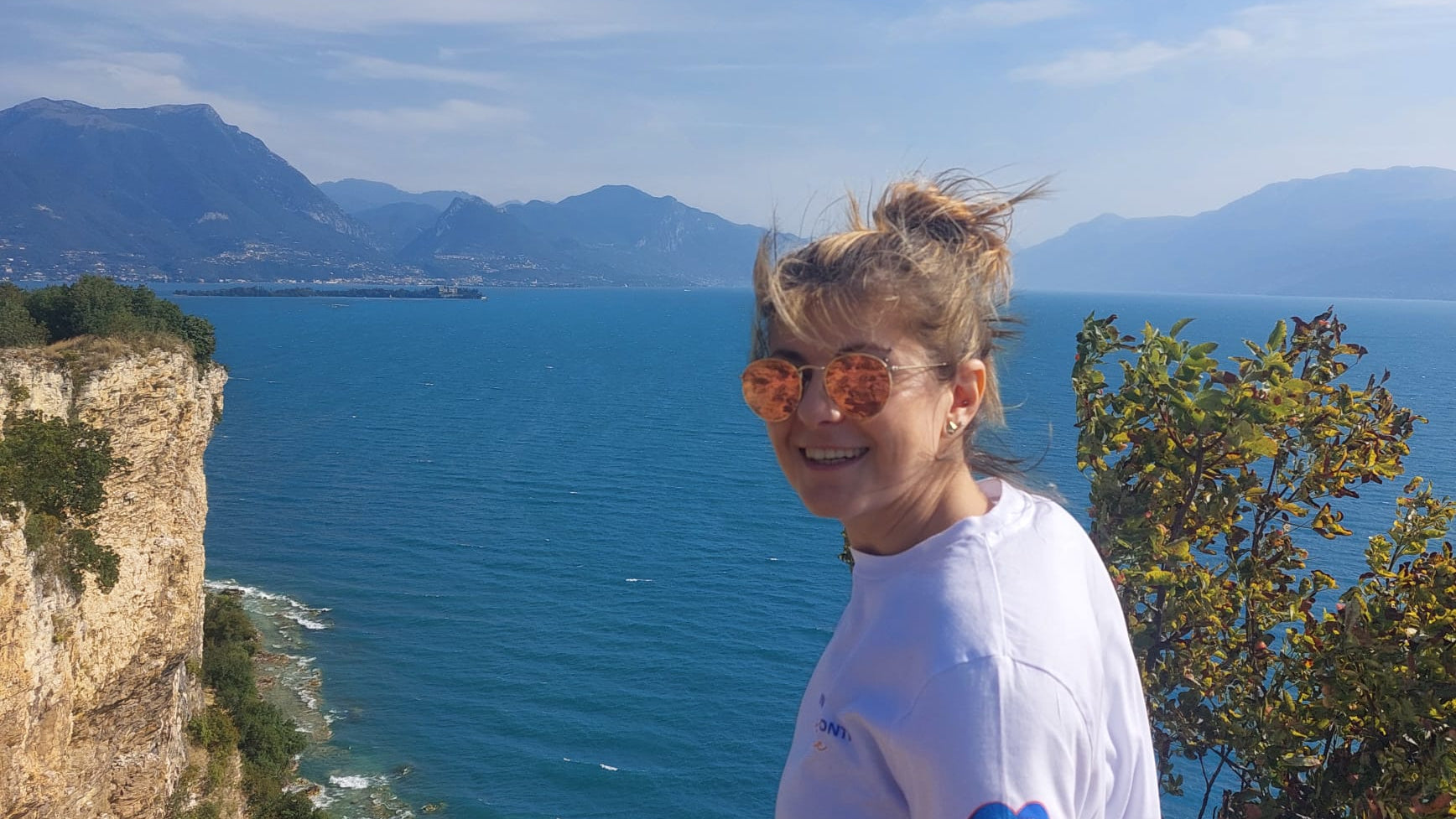 Iulia con dietro una veduta dal alto di una scogliera sul Lago di Garda
